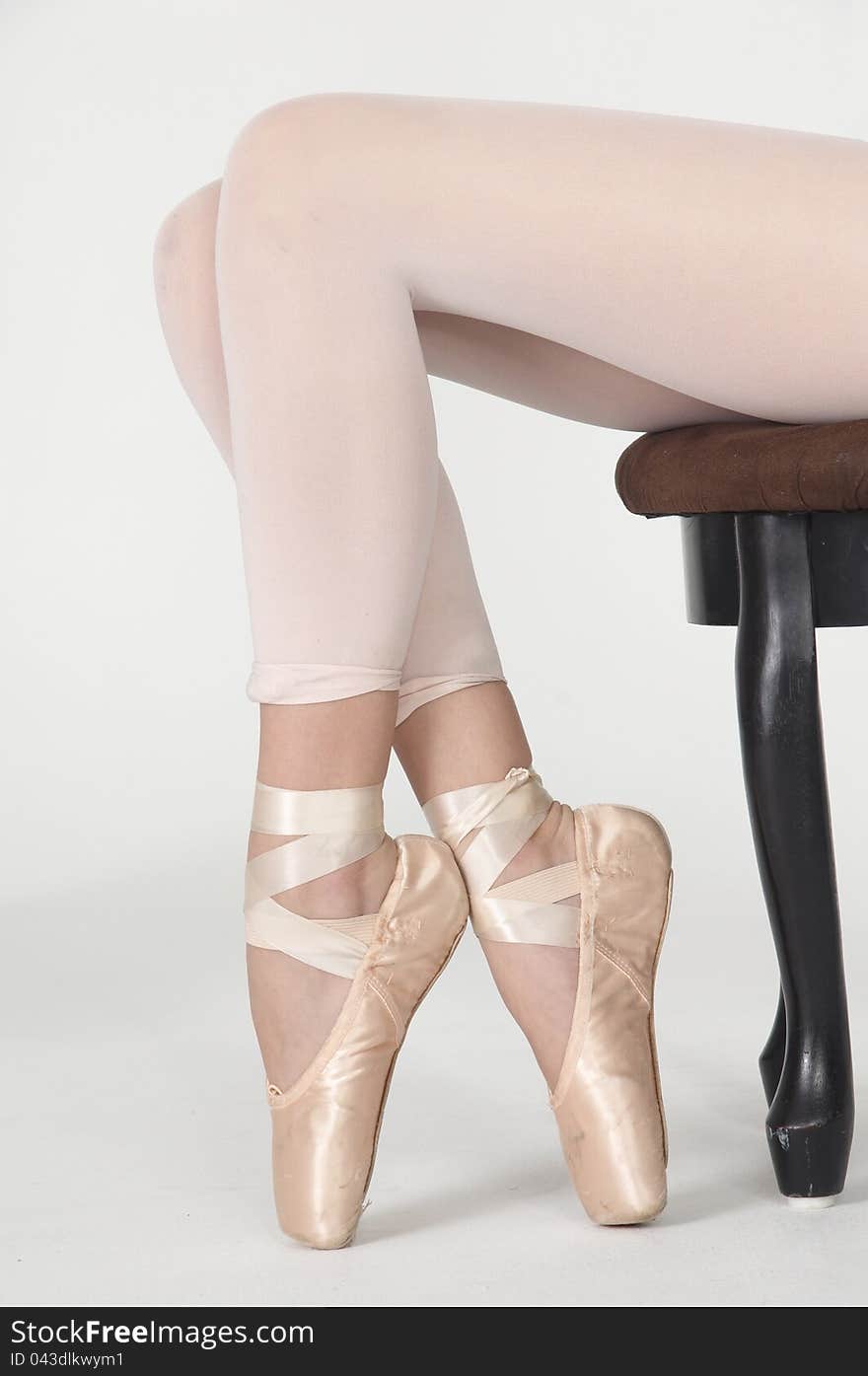 Seated Ballerina s Legs on Pointe in White Tights