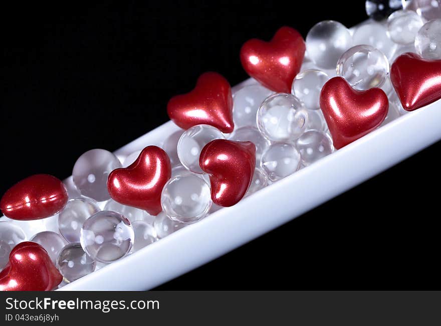 Red hearts and white jelly balls love decoration on black background. Red hearts and white jelly balls love decoration on black background