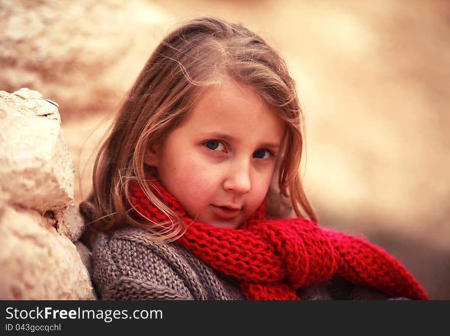 Little sweetie girl child in a red scarf