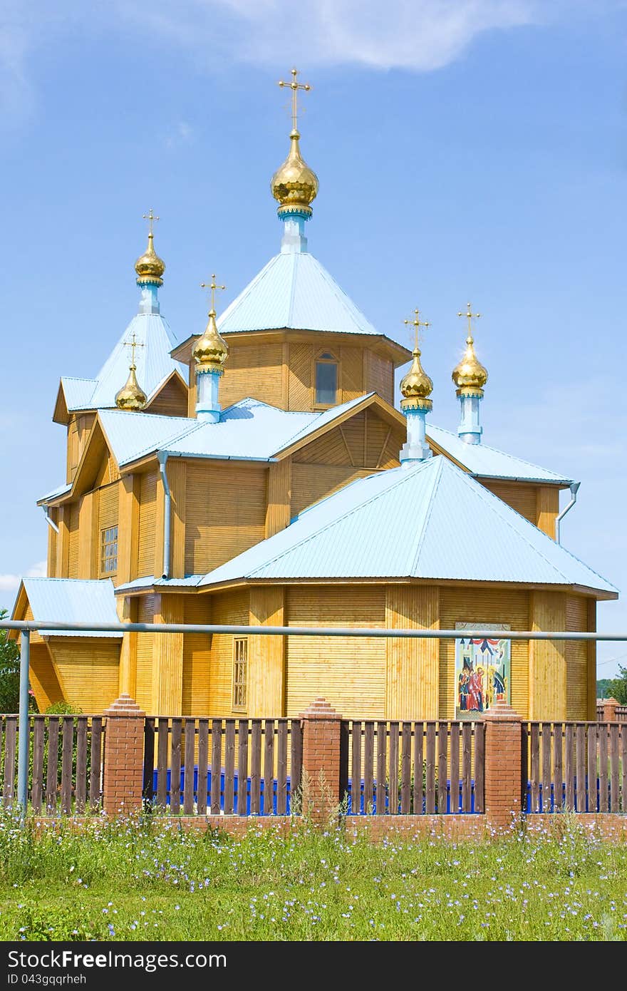 A small rural church in the background of blue sky