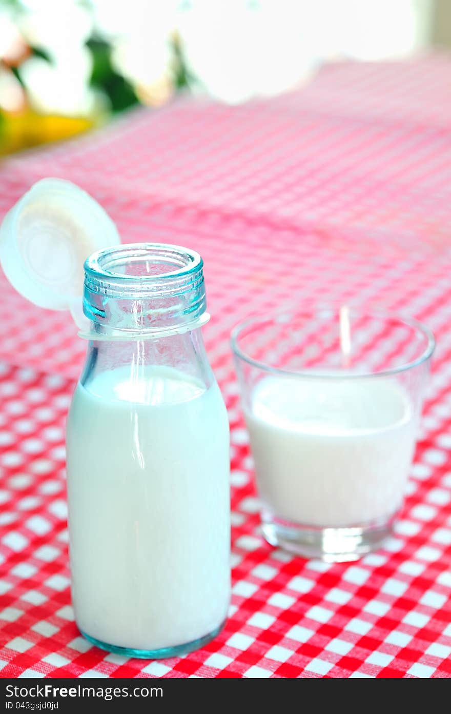 Glass of milk and bottle on table