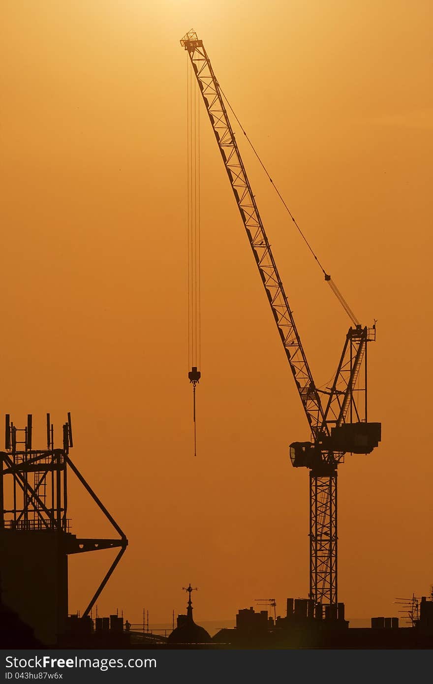 Cranes on a sunset background. Industrial scene. Cranes on a sunset background. Industrial scene