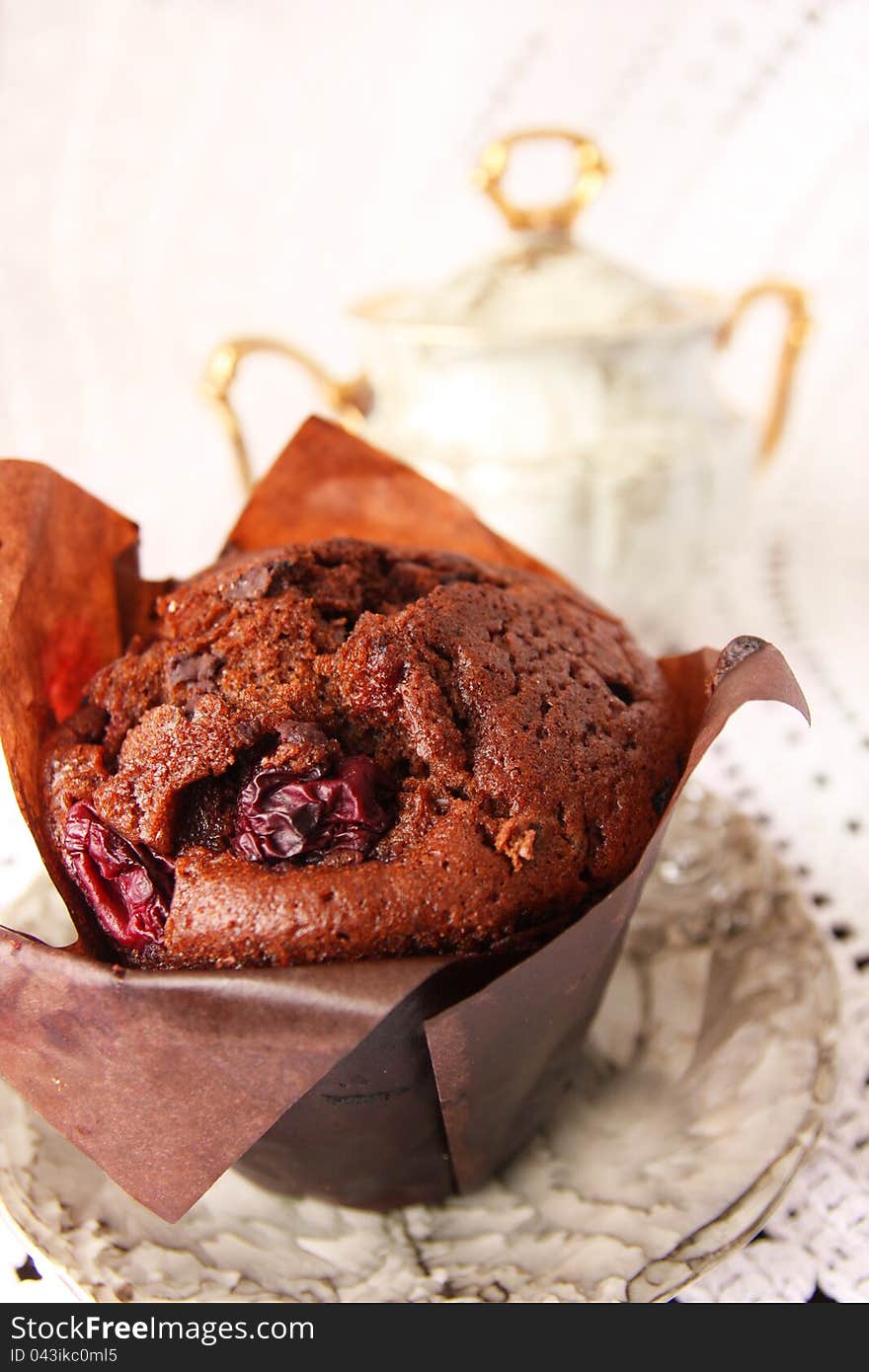 Delicious chocolate muffin in a porcelain saucer