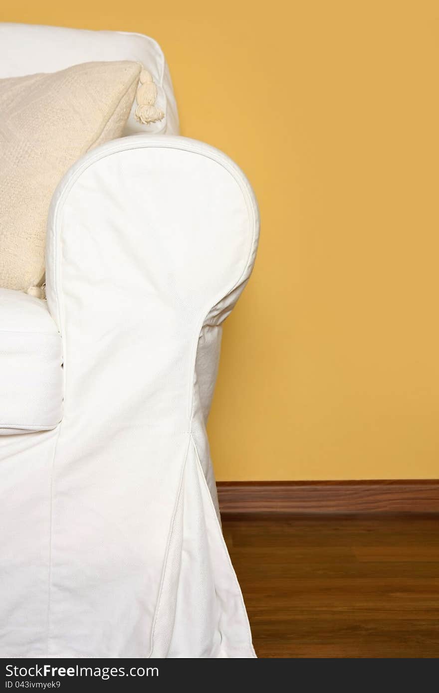 Details shot of a white couch near yellow wall