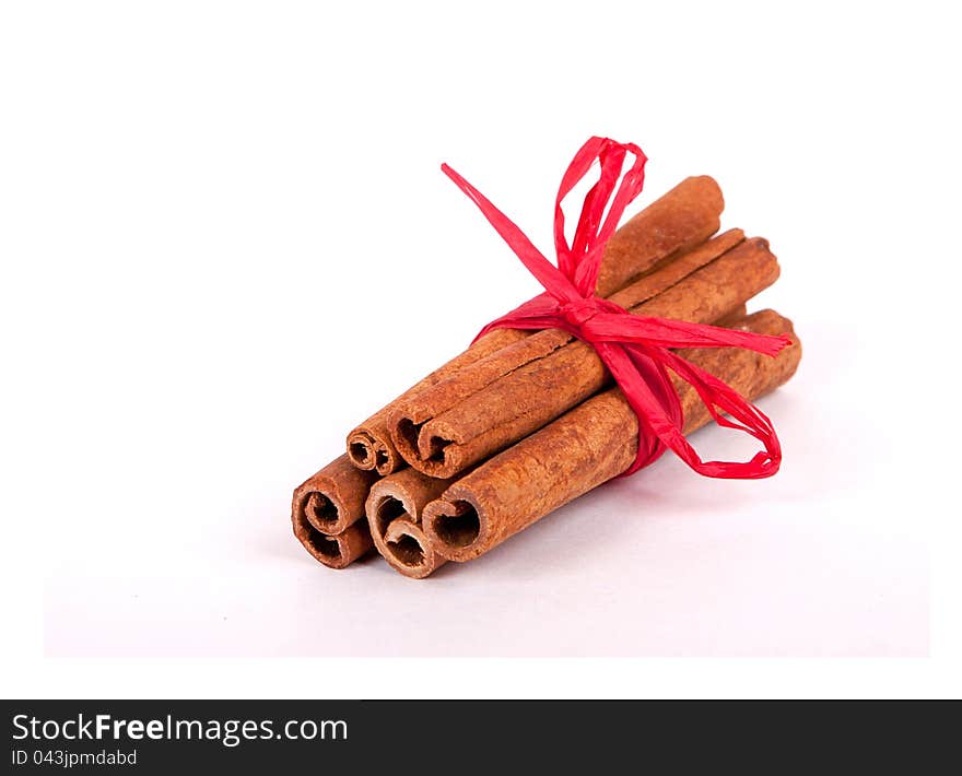 Cinnamon Sticks with red ribbon on white background