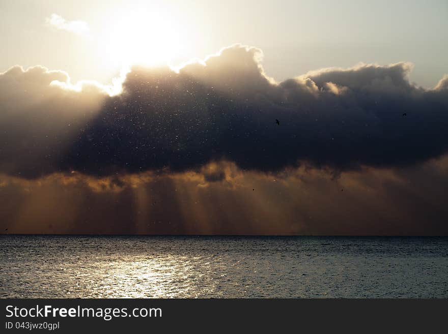 Clouds filter sunrays and darken. Clouds filter sunrays and darken.