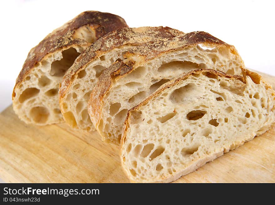 Freshly baked bread sliced on a wooden board. Freshly baked bread sliced on a wooden board.