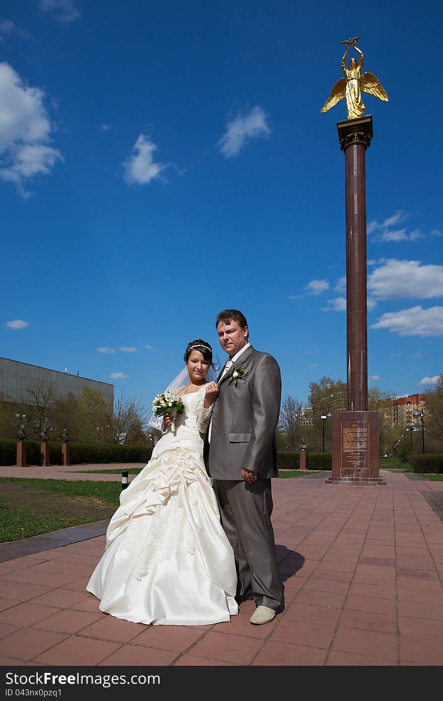 Bride and groom on the background of the monument