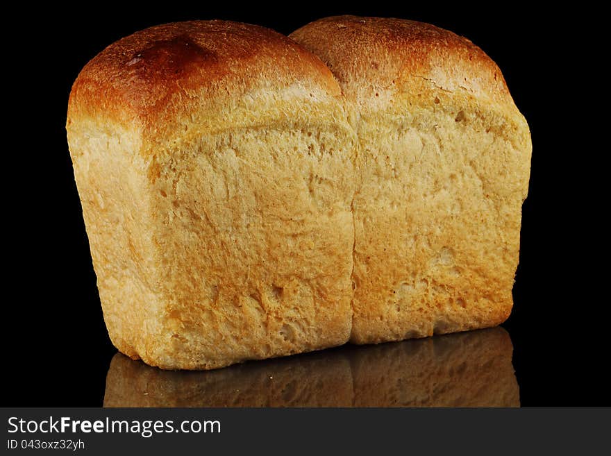 A loaf of bread on a black background. A loaf of bread on a black background.