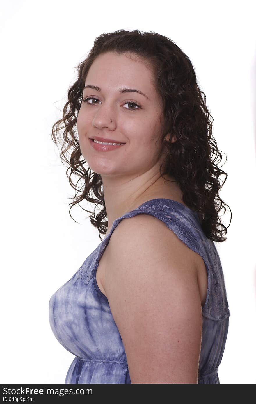 A young woman in a blue blouse turned to the side and smiling. A young woman in a blue blouse turned to the side and smiling