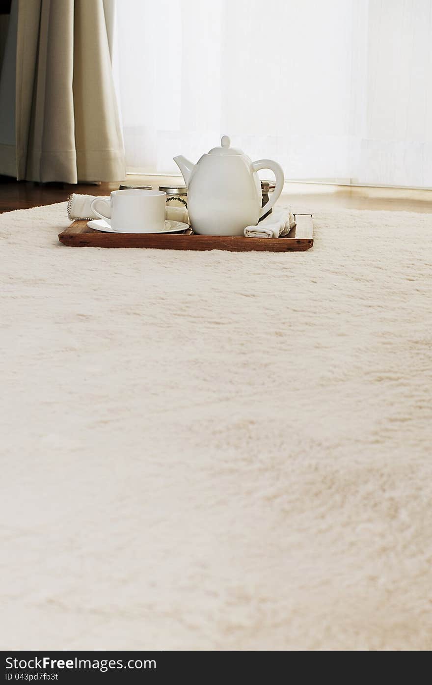 White color tea set on a carpet in a room. White color tea set on a carpet in a room