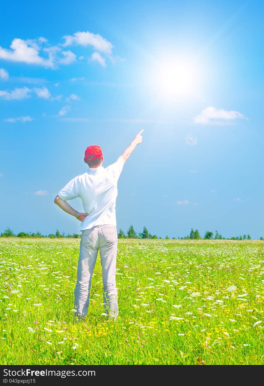 Man in the green meadow in sunny day