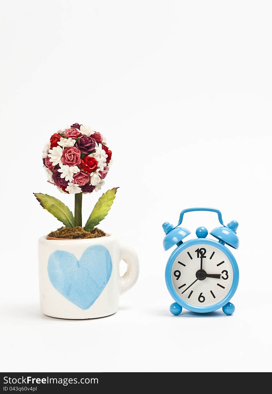 Blue cup wiht heart symbol and blue alarm clock isolated on white background