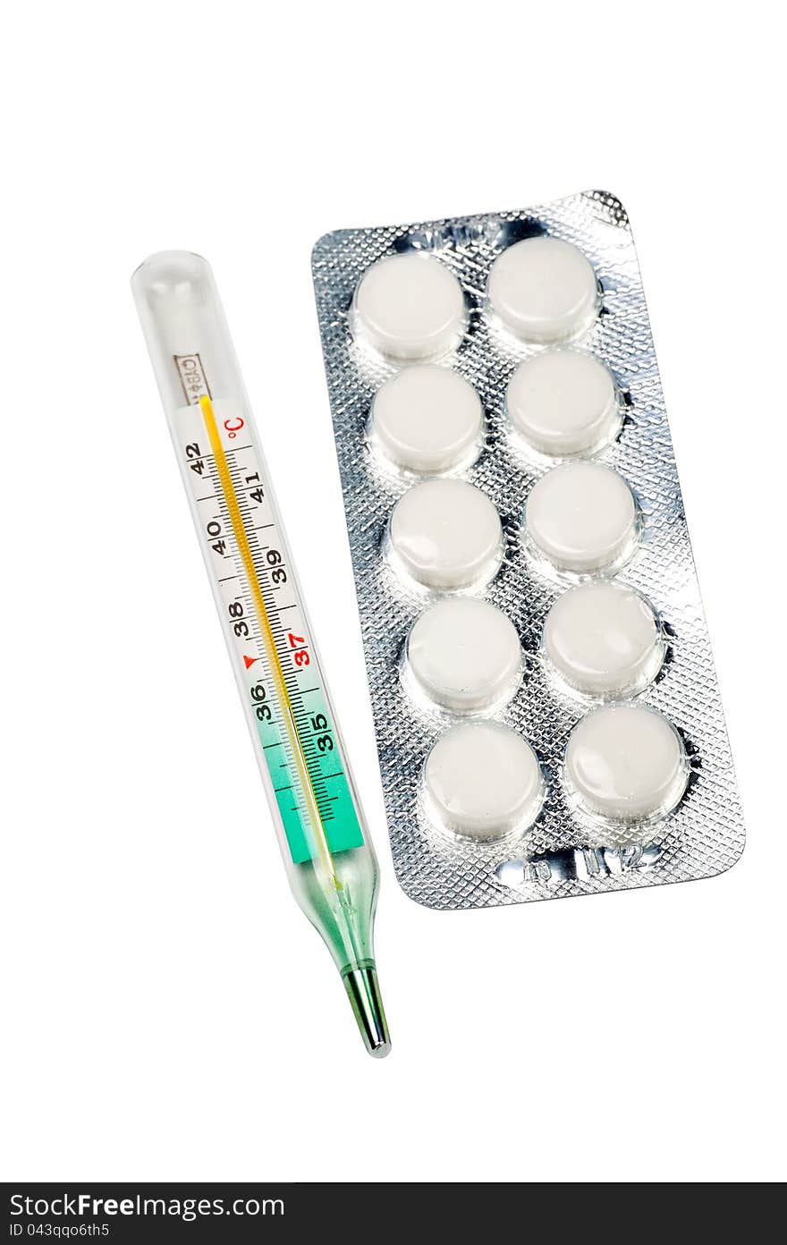 The medical thermometer and tablets on a white background