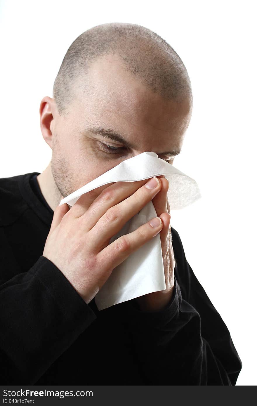 Young caucasian guy blowing nose in tissue. Young caucasian guy blowing nose in tissue