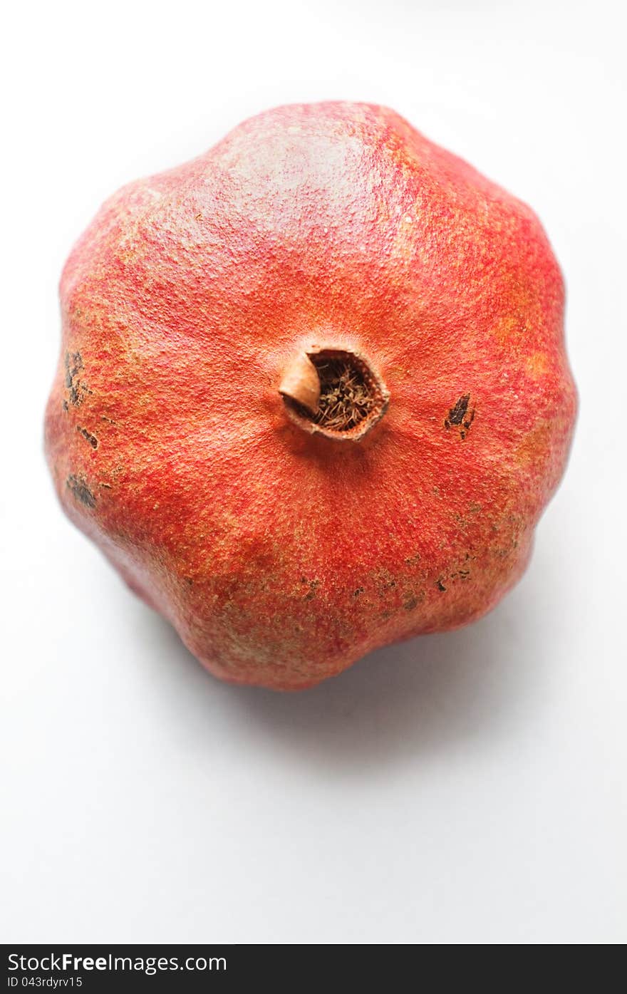 Top view of a ripe pomegranate on grey background