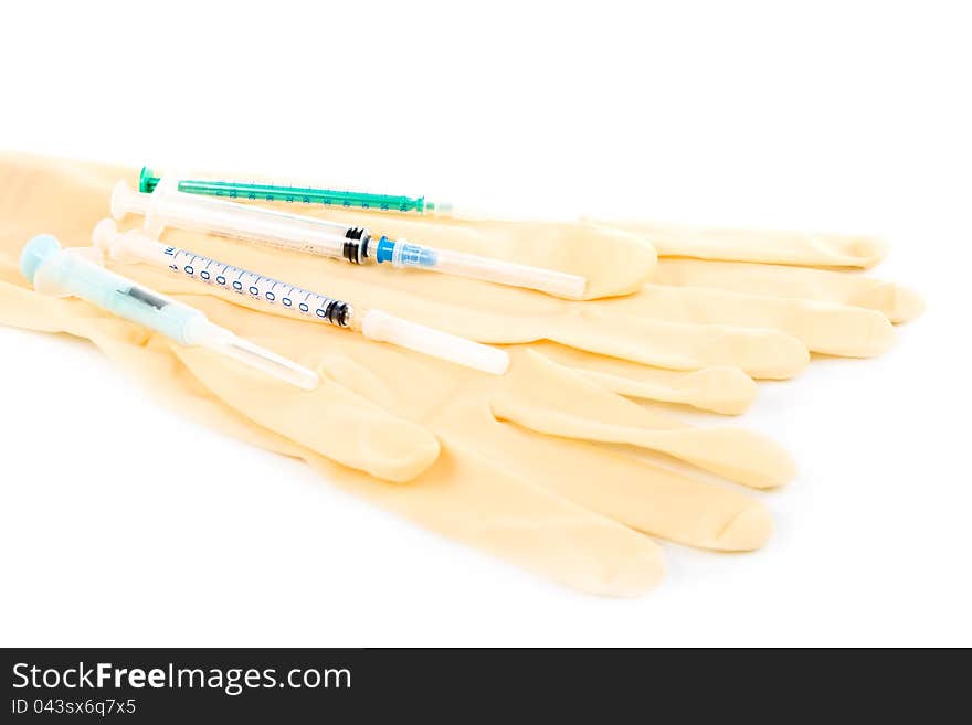 Several syringes and medical gloves on a white background. Several syringes and medical gloves on a white background.