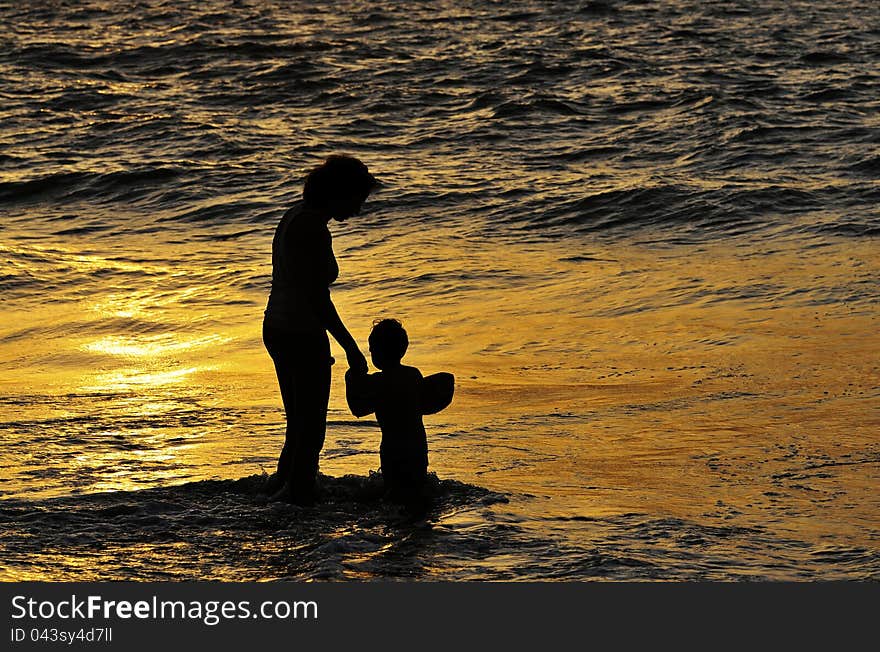 Mother and his son having good time on a beach at dusk. Mother and his son having good time on a beach at dusk.