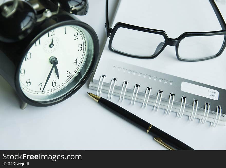 Clock pen on a table, Glasses on diary. Clock pen on a table, Glasses on diary