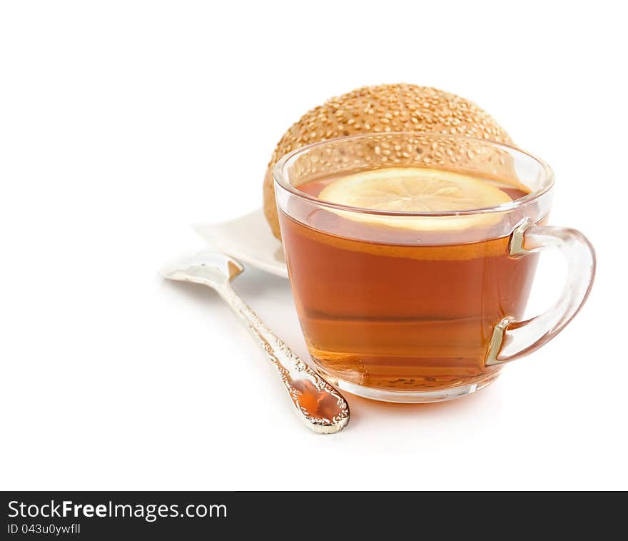 Cup Of Black Tea With A Lemon, Tea Spoon And Roll