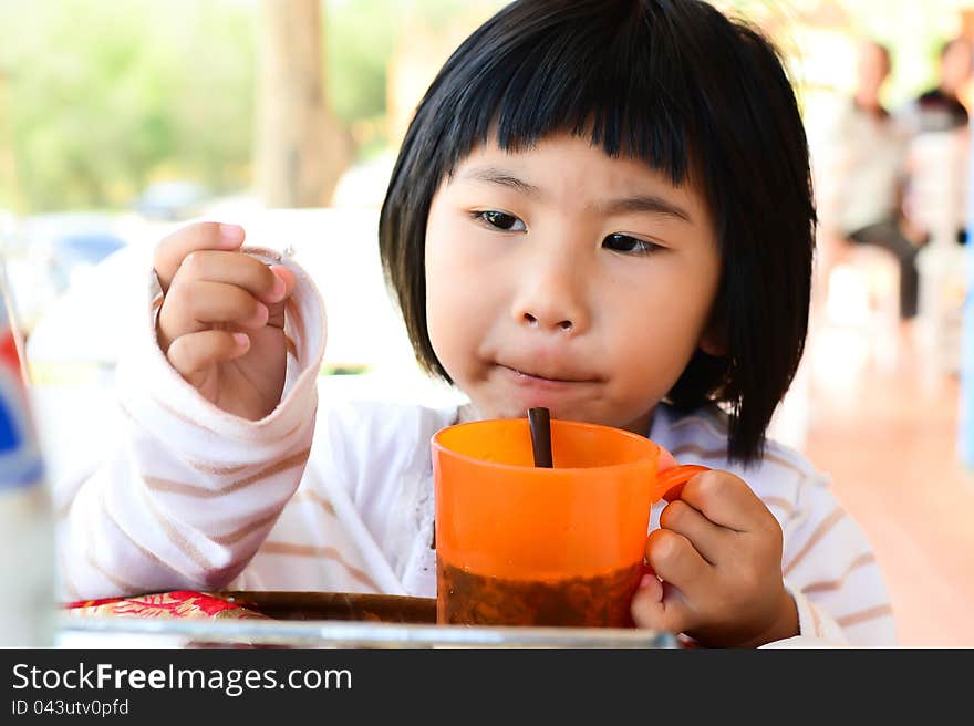 Little Asian Girl holding glass for drink