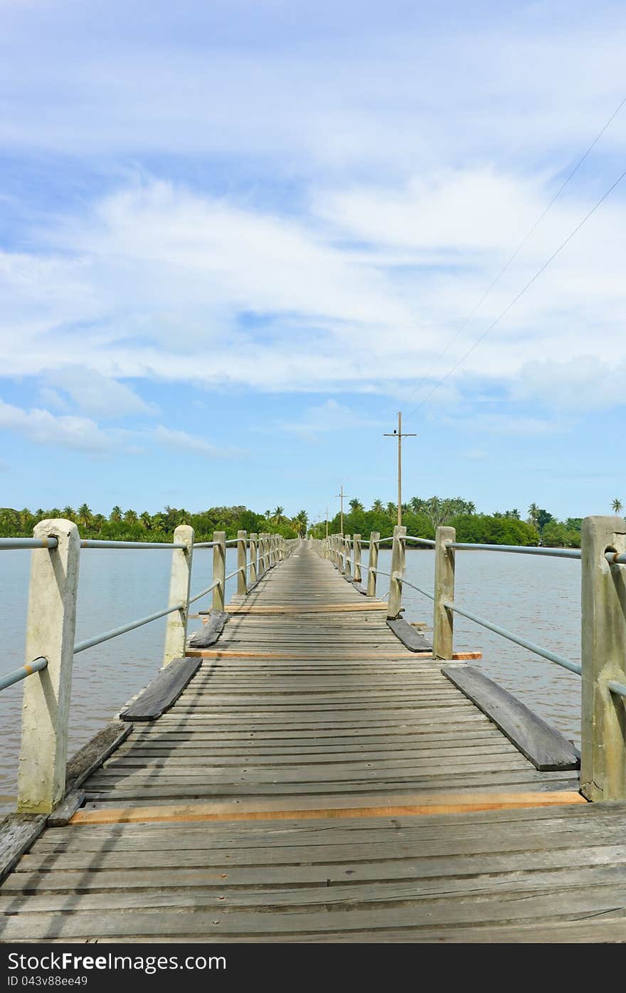 Long wood bridge over a river in low angle view, Thailand