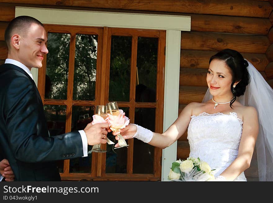 Happy young pair on a background of a wooden house