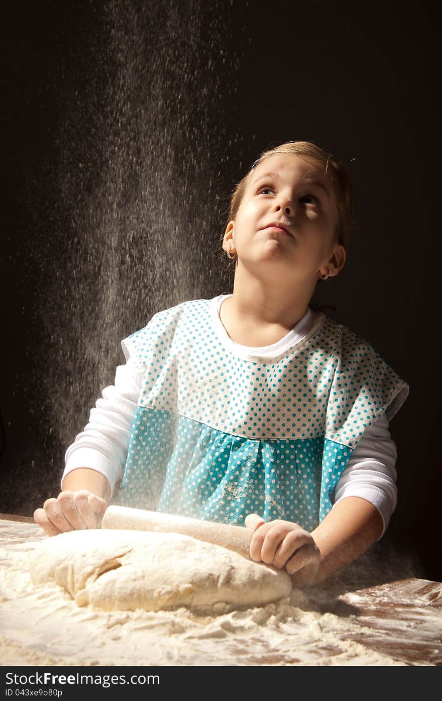 Little girl playing in the kitchen while helping in the making of bread and looking flour. Little girl playing in the kitchen while helping in the making of bread and looking flour