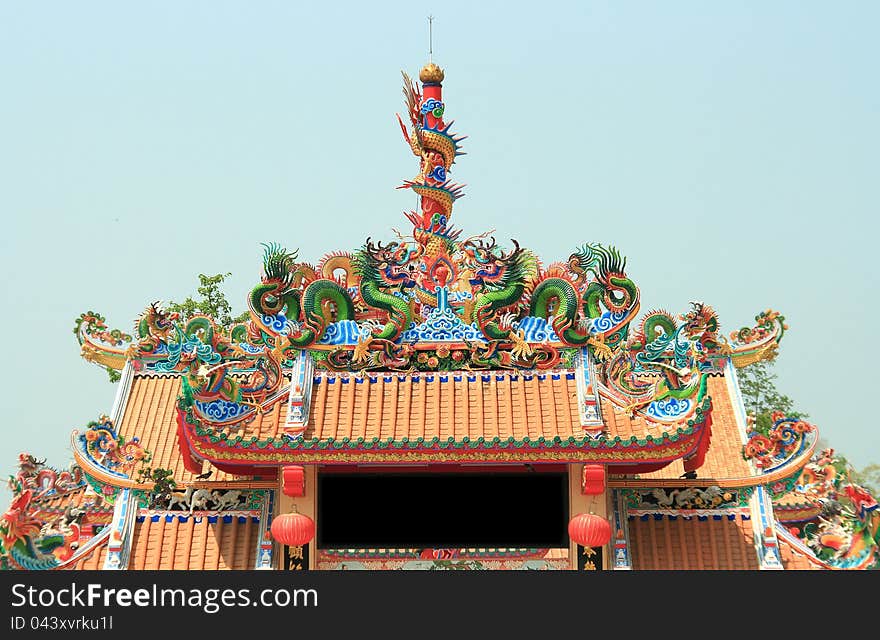 Dragon Statue on Top of Chinese Temple Shrine with blue sky