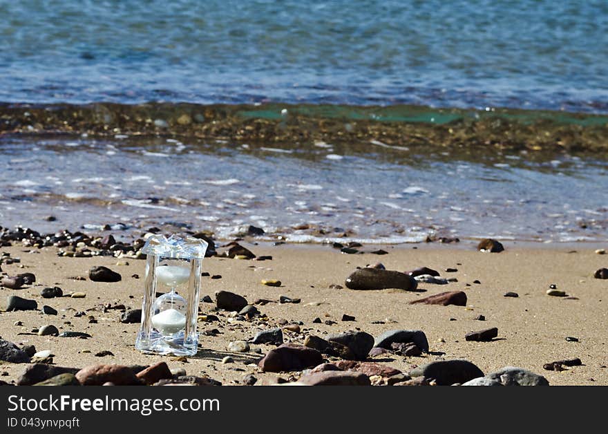 Crystal hourglass on marine beach