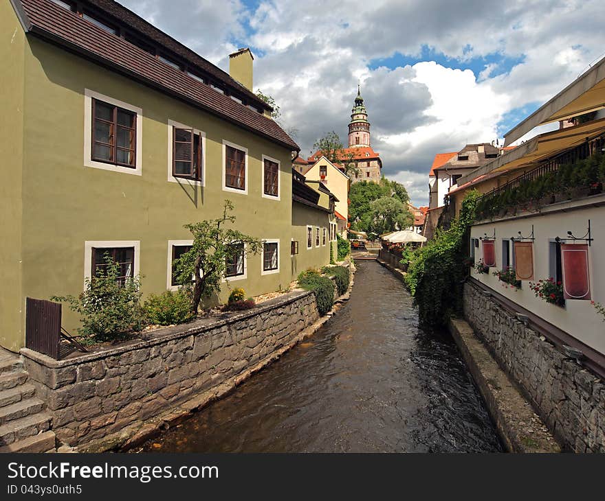 Narrow side canal at Cesky Krumlov. Cesky Krumlov is a small city in the South Bohemian Region of the Czech Republic, best known for the fine architecture and art of the historic old town.