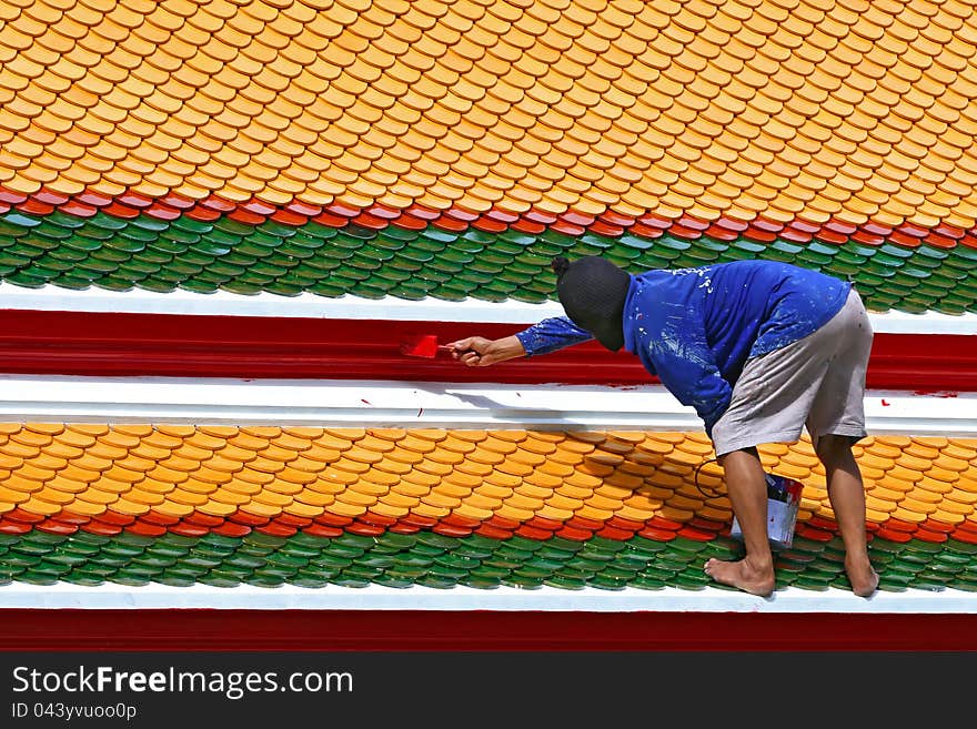 Worker painting temple roof for renovate