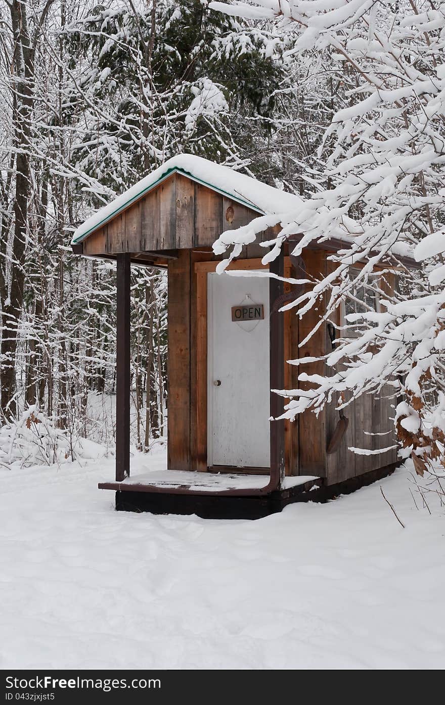 Rustic wooden outhouse in winter