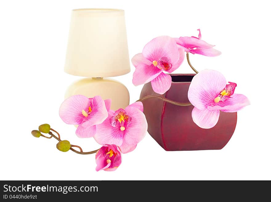 Modern table lamp and branch of artificial orchid flower in pot isolated on white. Modern table lamp and branch of artificial orchid flower in pot isolated on white