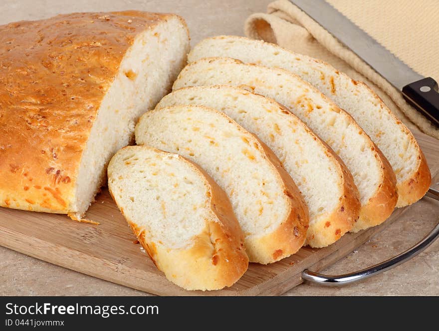 Sliced cheddar cheese bread on a cutting board. Sliced cheddar cheese bread on a cutting board