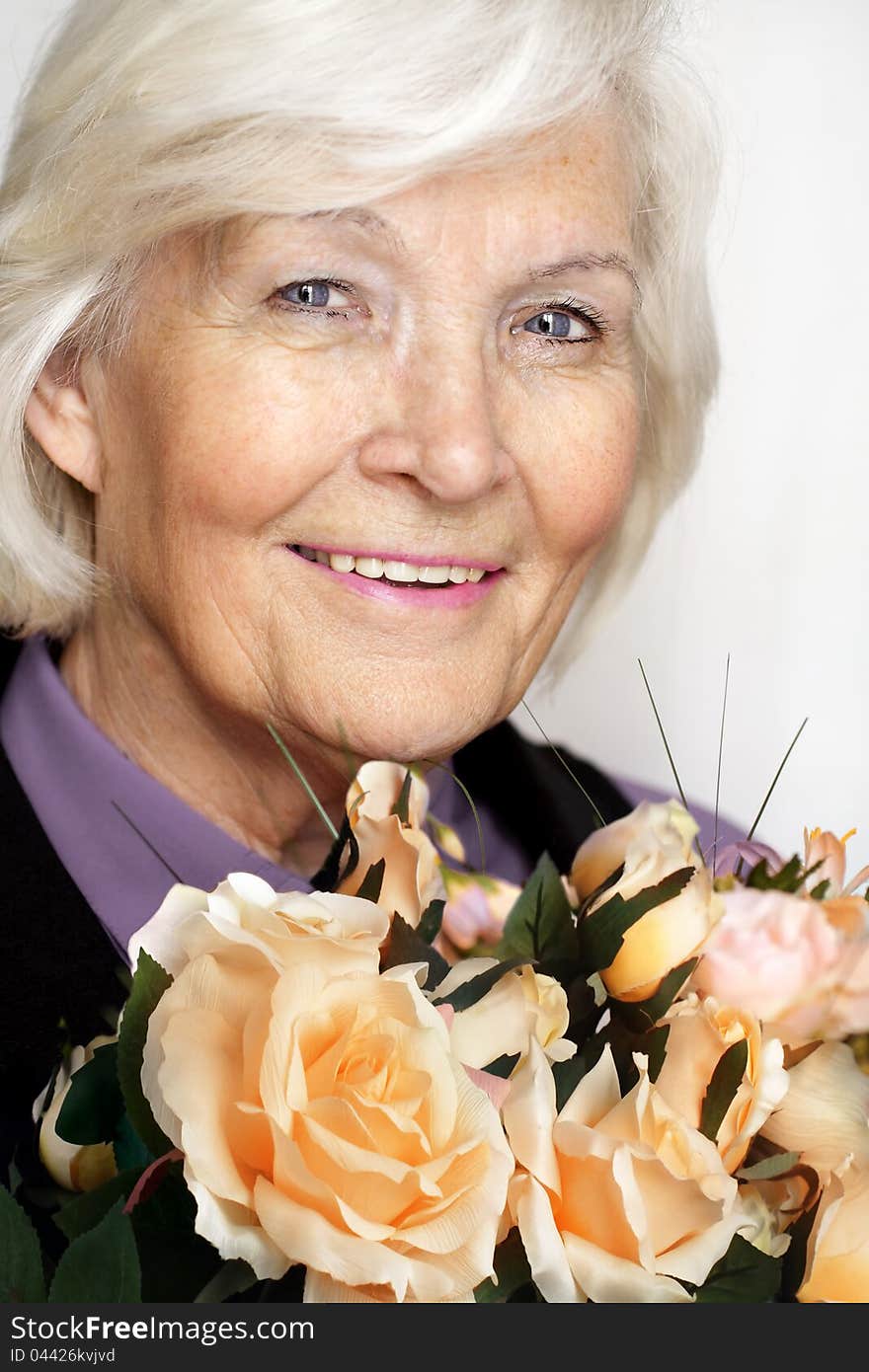 Senior woman portrait, smiling with a bunch of roses. Senior woman portrait, smiling with a bunch of roses