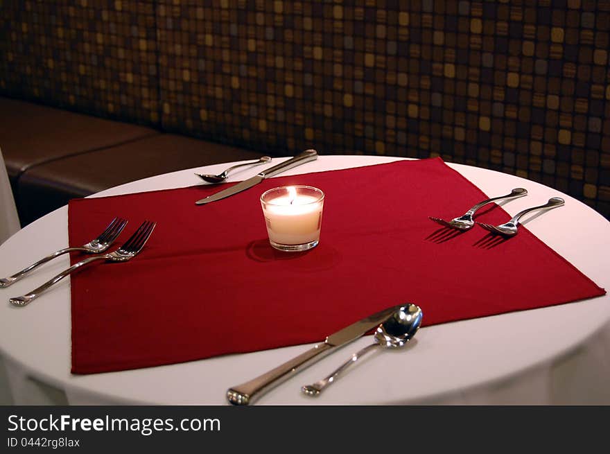 A candle lit set dinner table for two. A candle lit set dinner table for two.