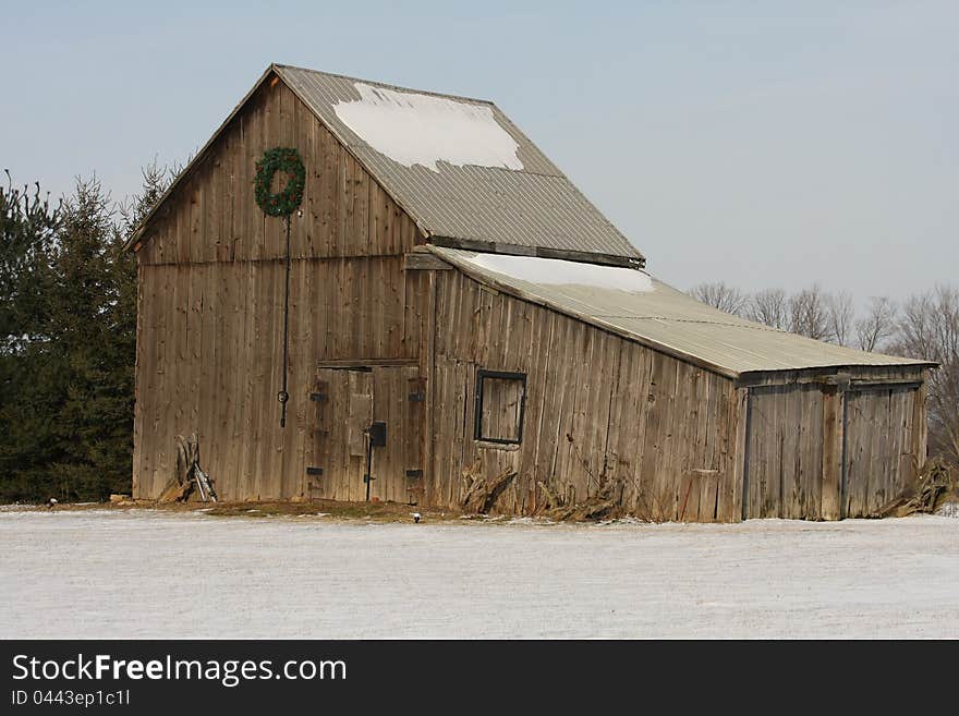 Old barn in winter with snow on ground and roof. Old barn in winter with snow on ground and roof