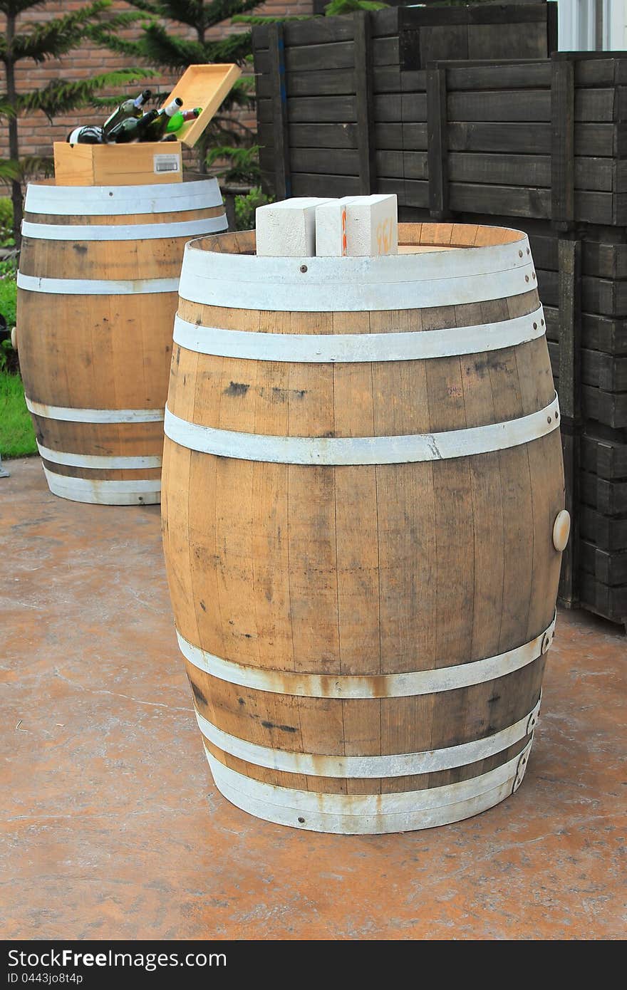 Two wine barrels on concrete floor.