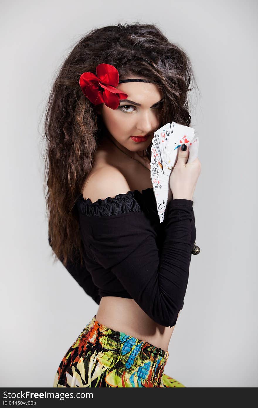 Beautiful gypsy with curly hair and cards in their hands. Beautiful gypsy with curly hair and cards in their hands