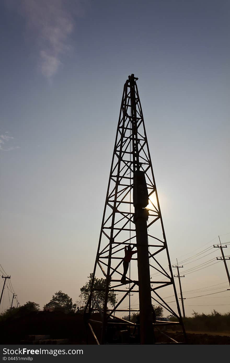 Silhouette of a worker in a Derrick, with sun shining through. Silhouette of a worker in a Derrick, with sun shining through.