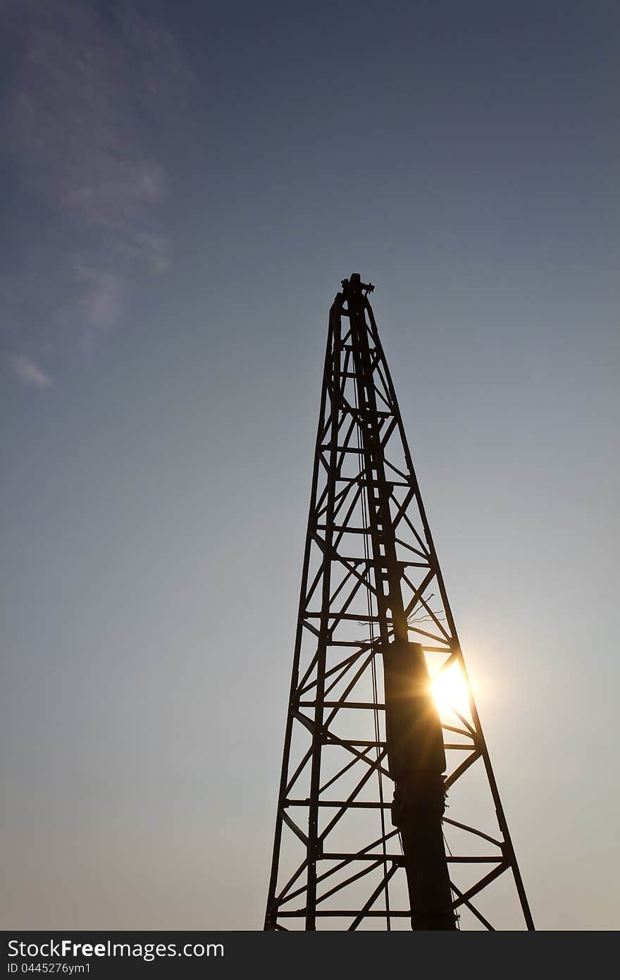 Silhouette of a worker in a Derrick, with sun shining through. Silhouette of a worker in a Derrick, with sun shining through.