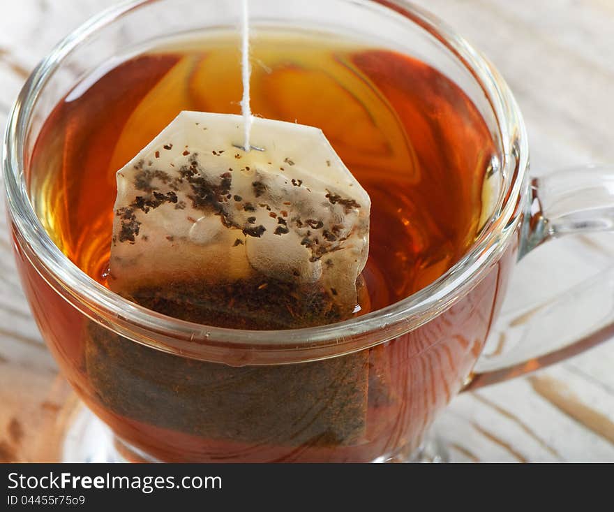 Teabag in the teacup on a wooden table. Teabag in the teacup on a wooden table