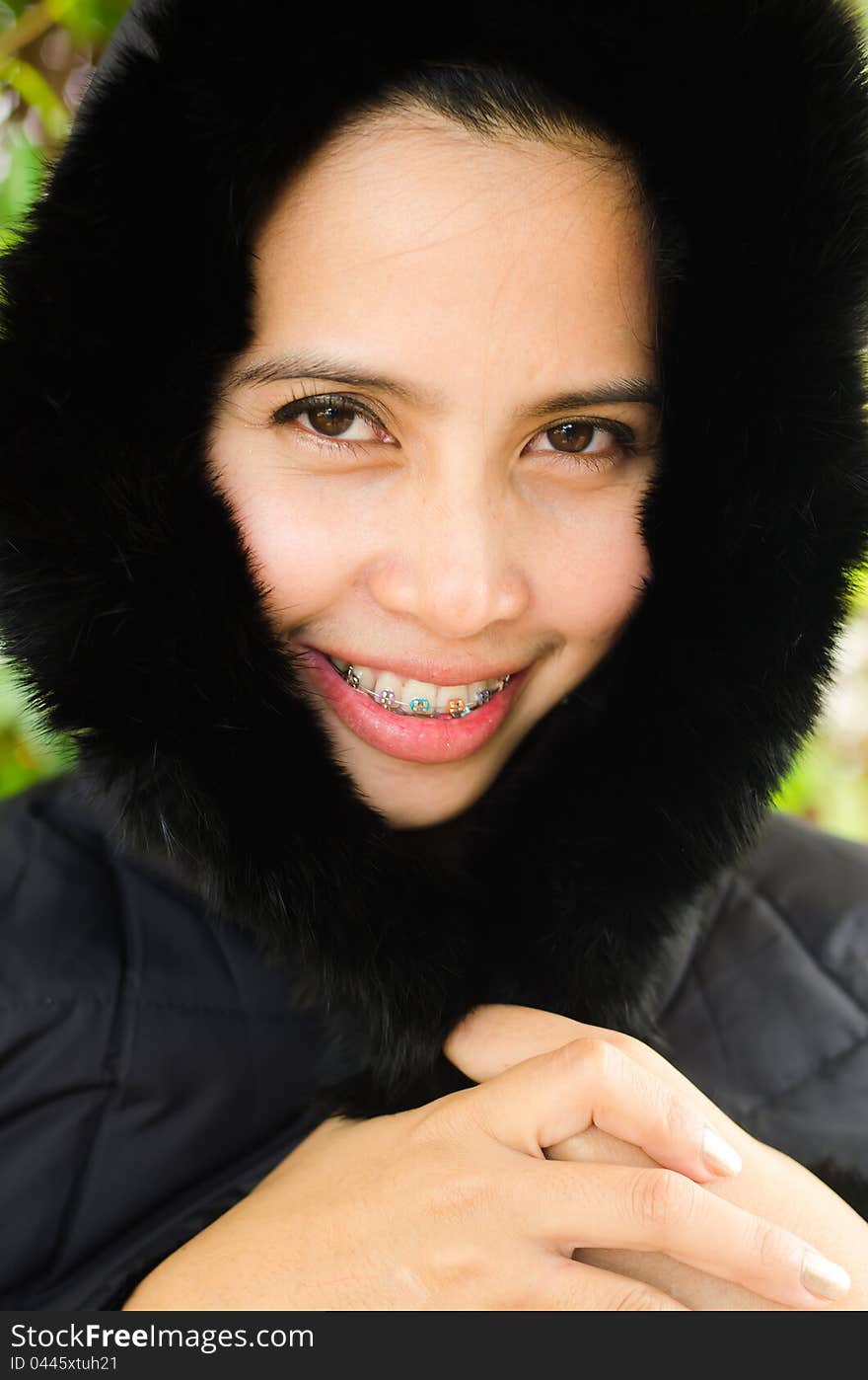 Portrait of a woman with black jacket and braces teeth