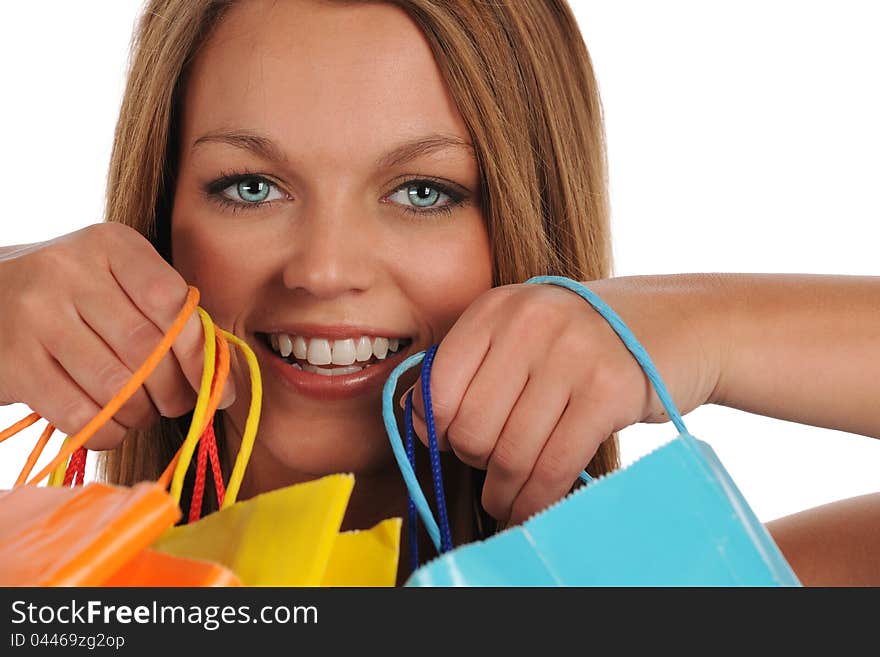 Young woman's portrait with colorful shopping bags isolated on a white background. Young woman's portrait with colorful shopping bags isolated on a white background