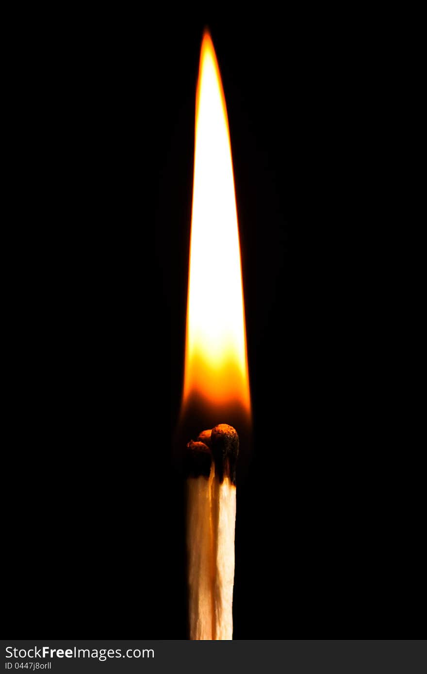 Burning match on black background