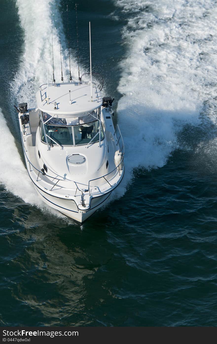 A speedboat moving through calm water in the Pacific Ocean.