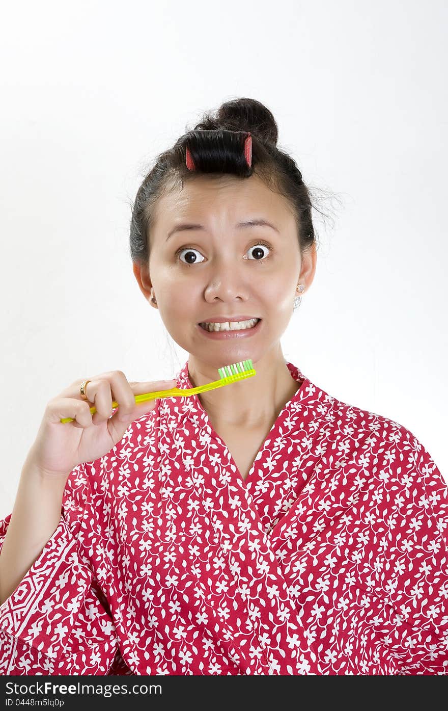 Woman with hair roll brush her teeth isolated over white background. Woman with hair roll brush her teeth isolated over white background