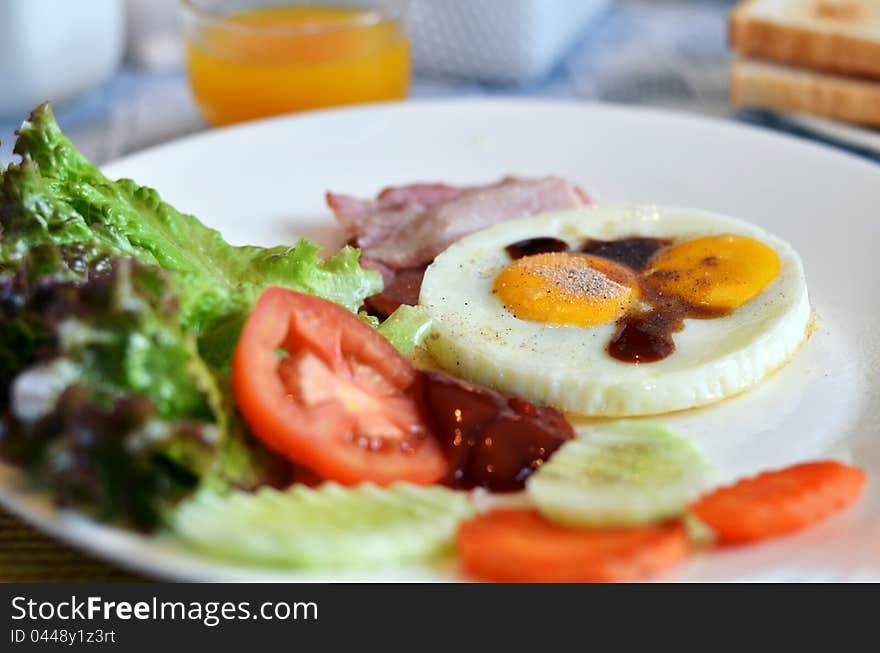 American style breakfast , with bacon, fried egg and fresh vegetables