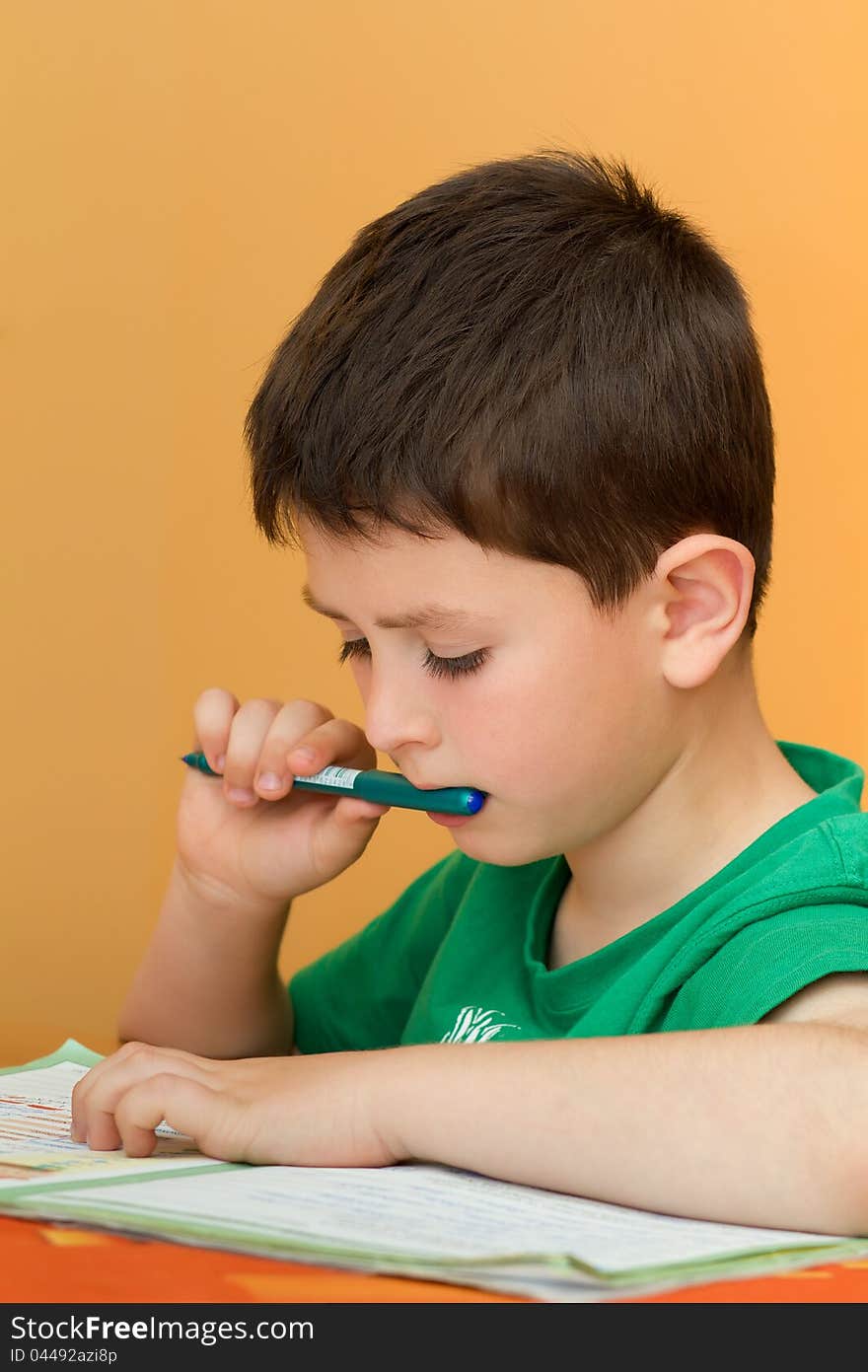 Boy thinking on homework from school in workbook. Boy thinking on homework from school in workbook